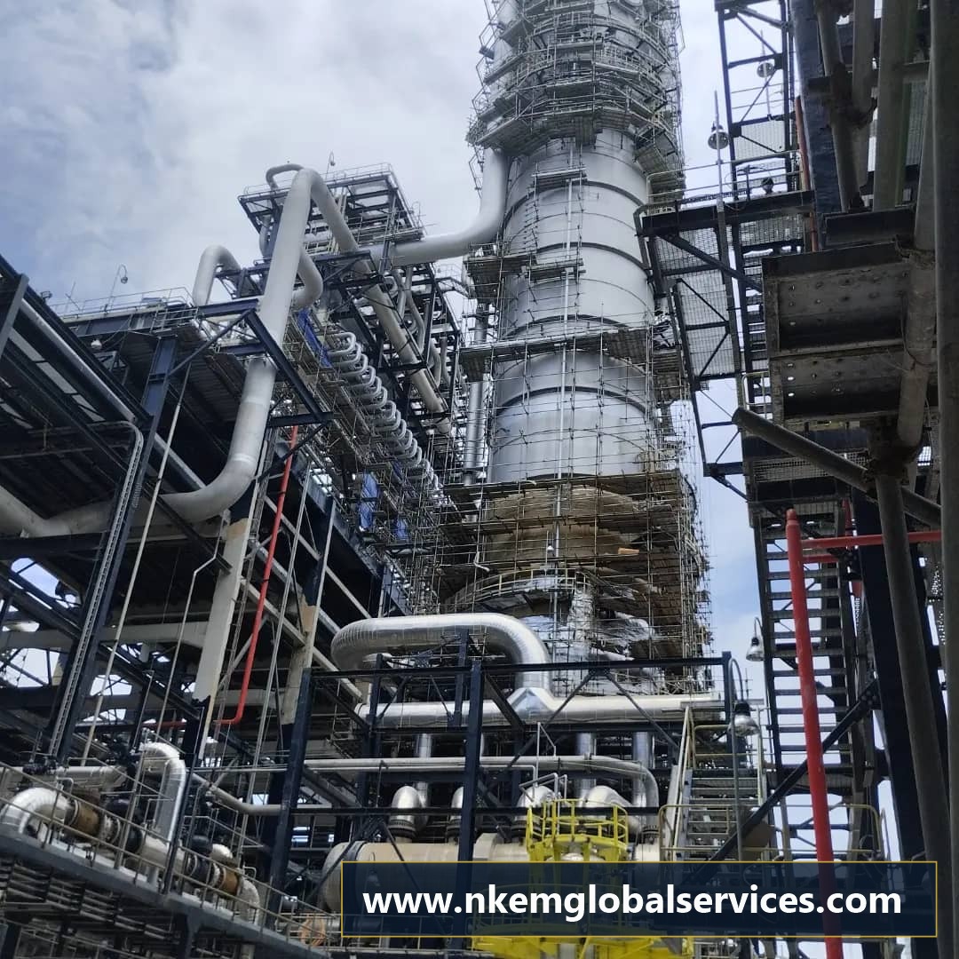Heavy process column under complex scaffolding during maintenance on an ongoing construction site